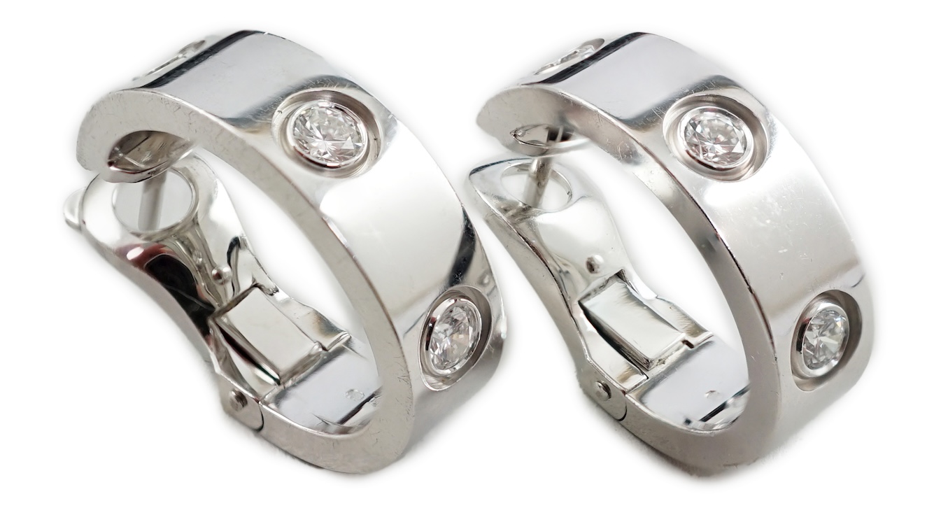 A pair of 2006 Cartier 18ct white gold and three stone round cut diamond set demi-lune earrings